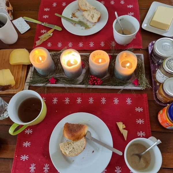 Ein Frühstückstisch mit Brötchen, Marmeladen, Käse, Kaffee, Tee.
