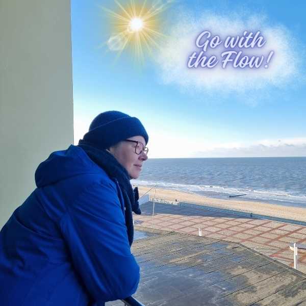 Die Autorin blickt von einem Balkon aufs Meer. Am Himmel eine durchscheinende Wolke mit der Schrift "Go with the Flow" und eine Sonne