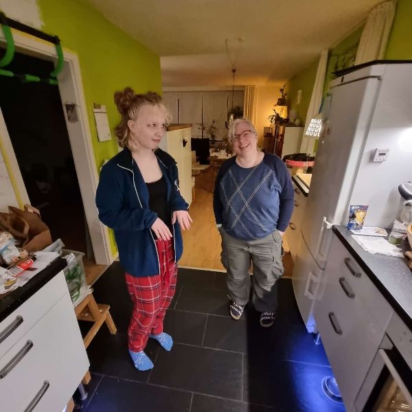 Die Tochter der Autorin und Britta Hohne stehen in einer Küche und unterhalten sich amüsiert.
