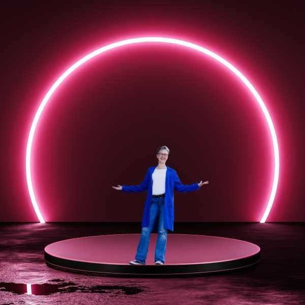 Eine Frau in Blau steht auf einer runden Bühne, umleuchtet mit einem rötlichen Halbkreis