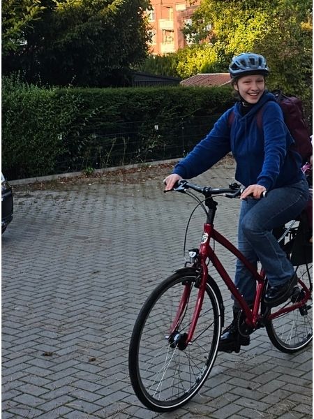 Die Tochter der Autorin sitzt strahlend auf ihrem roten Fahrrad; hinten im Anschnitt sieht man einen Kinder-Fahrradsitz.